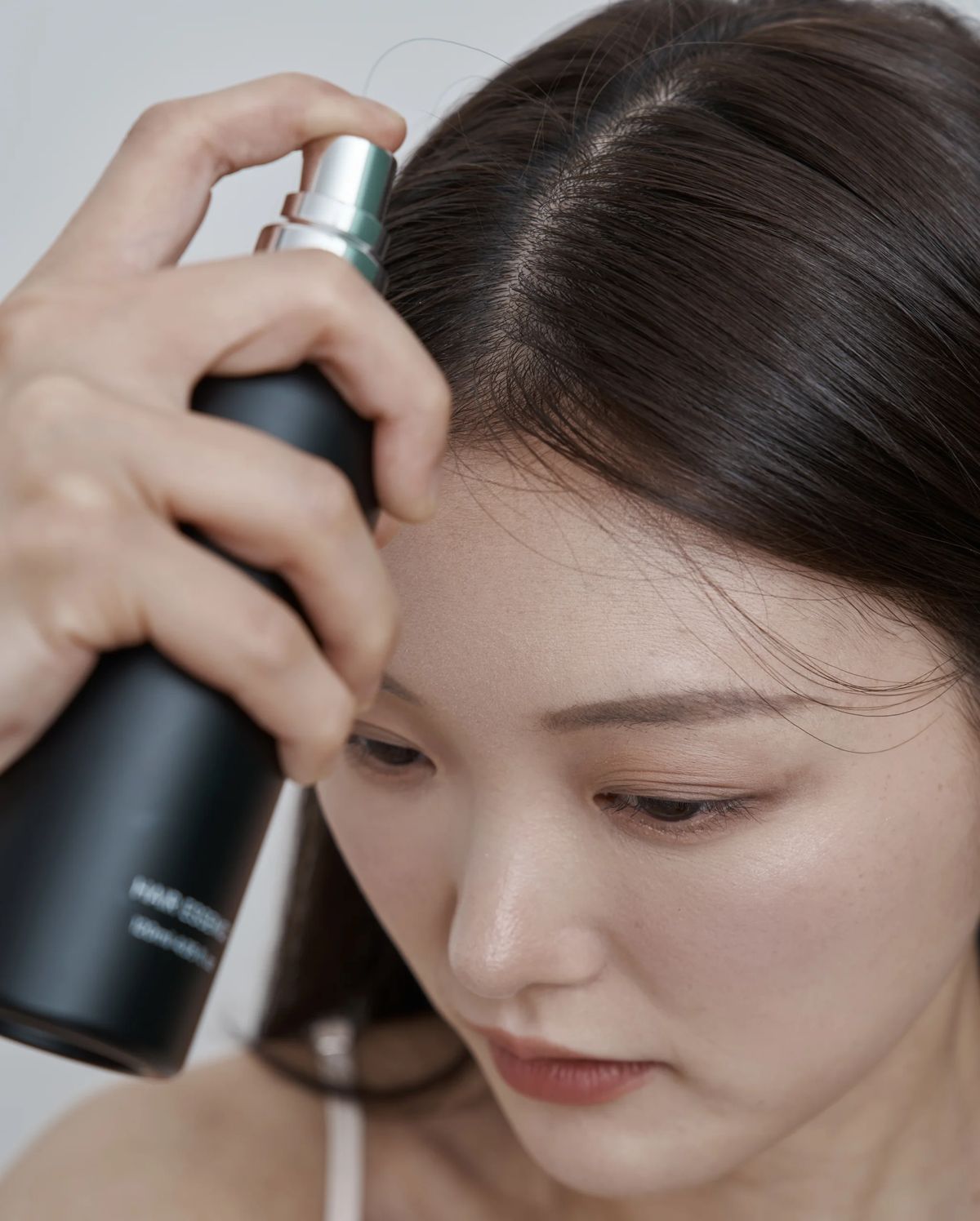탈모증상완화토닉을 가르마 부분에 뿌리는 모습